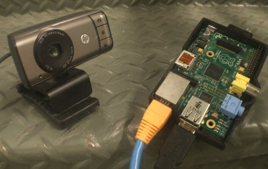 Photo of an HP 3100 Webcam next to a Raspberry Pi in a 3D printed case